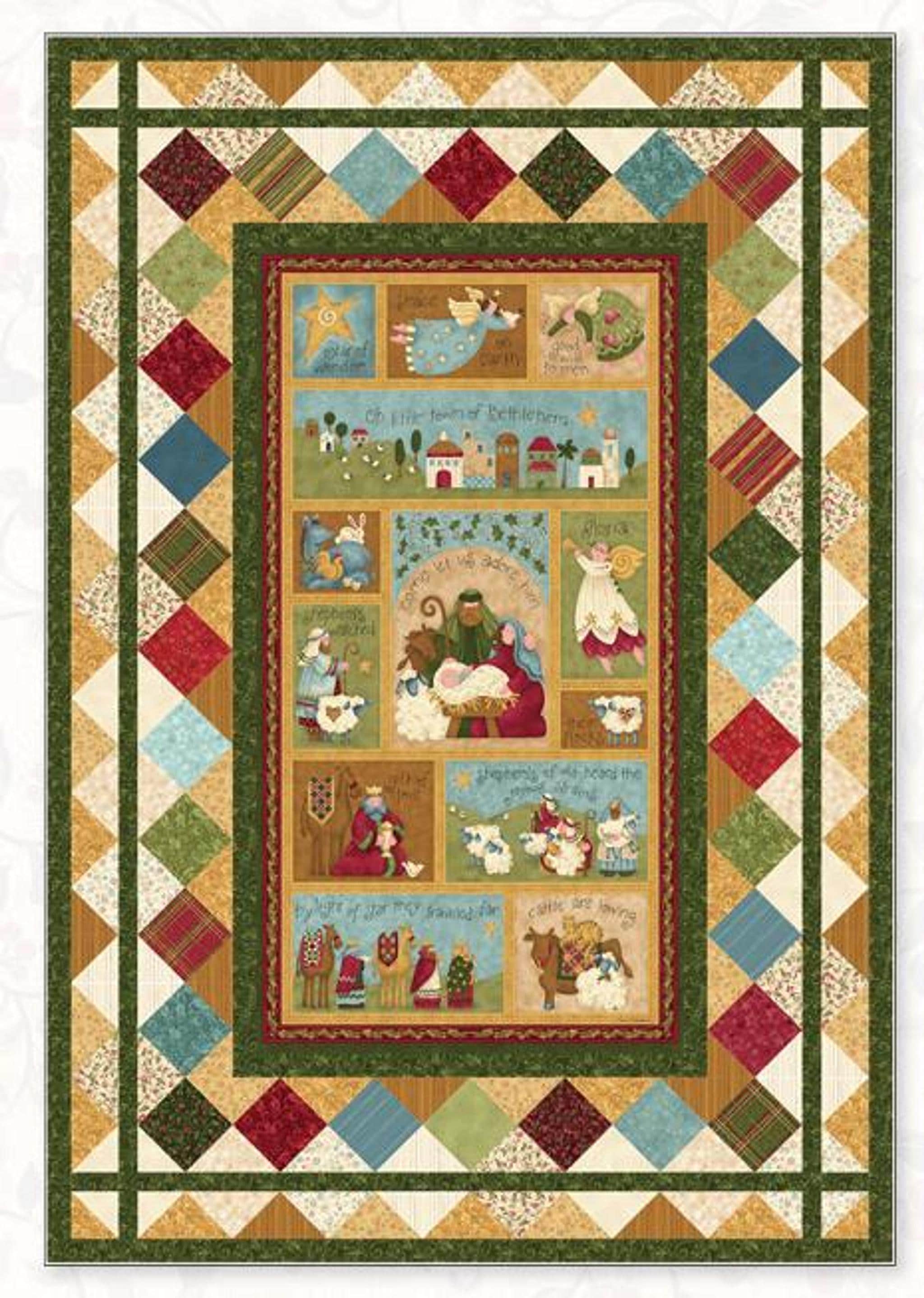 A quilt with a central panel depicting the Nativity scene in various vignettes, surrounded by a border of green, red, and gold diamond-patterned fabric.