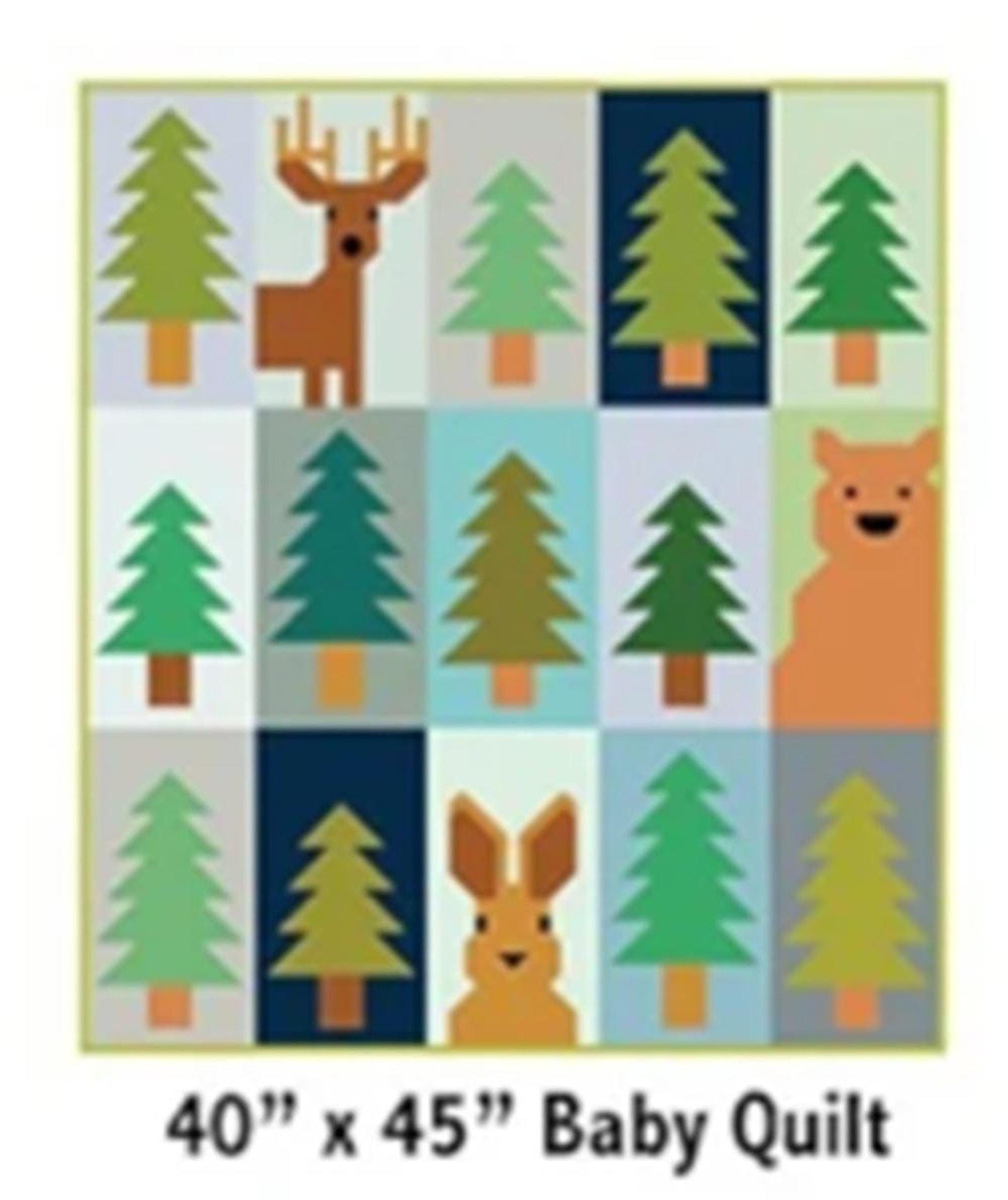 A quilt with a grid pattern of green trees, a brown deer, a brown bear, and a brown rabbit on light blue, dark blue, and tan squares.